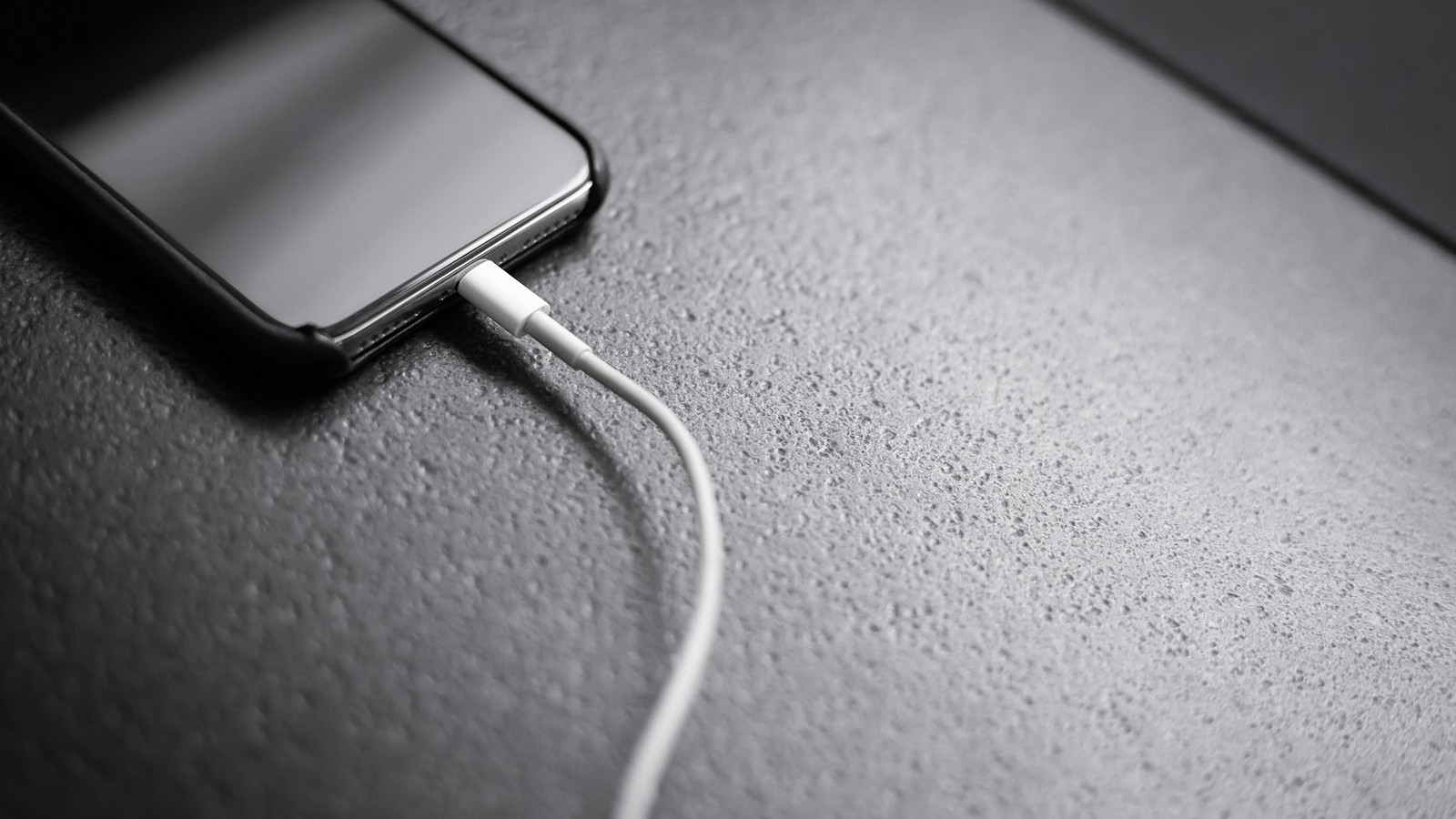 Een smartphone aan de lader, niet een van de genoemde toestellen (archiefbeeld)